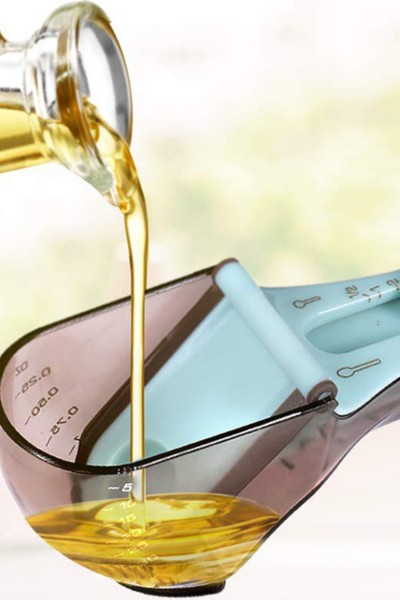 Odmierzanie oliwy za pomocą łyżeczki z miarką