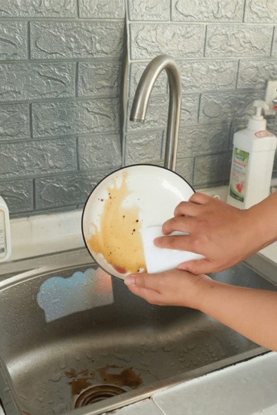 Mycie talerza magiczną gąbką do mycia naczyń