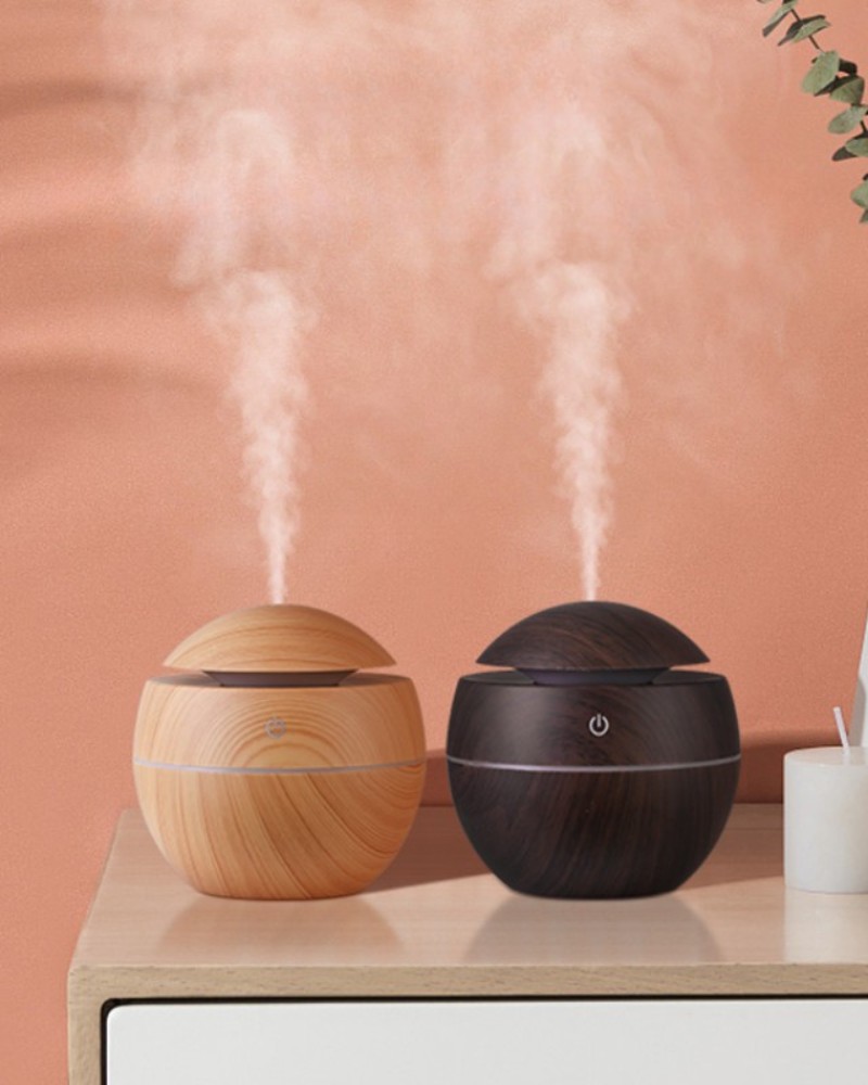 Nawilżacz powietrza w kształcie kuli Dwa nawilżacze w kolorze brązowego drewna i czarnego drewna na stole