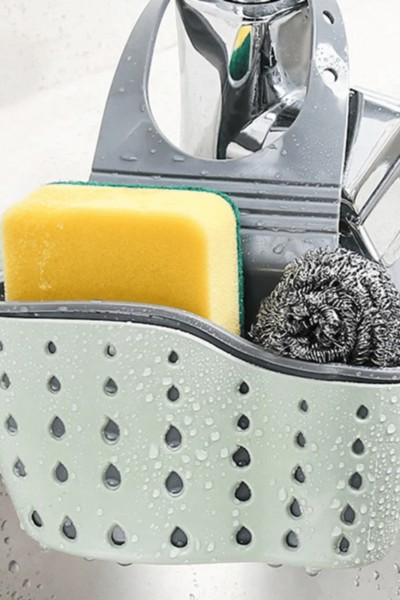 Przybornik zawieszony na kranie z gąbkami w środku