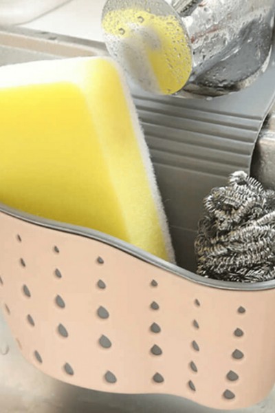 Przybornik zawieszony na kranie z gąbkami w środku