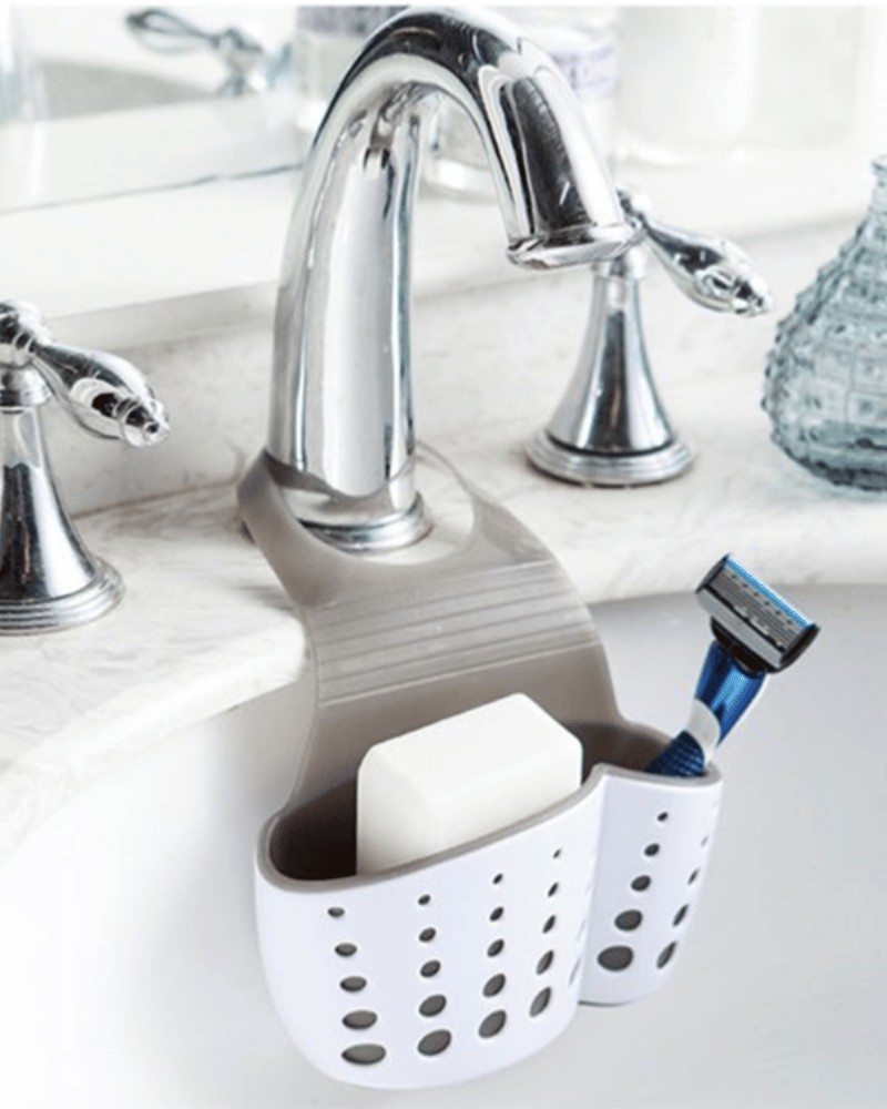 Przybornik zawieszony na kranie z mydłem i maszynką do golenia w środku