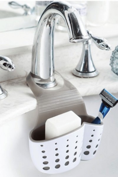 Przybornik zawieszony na kranie z mydłem i maszynką do golenia w środku