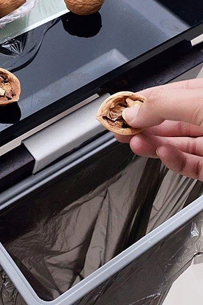 Wyrzucanie resztek jedzenia do worka na uchwycie do worków