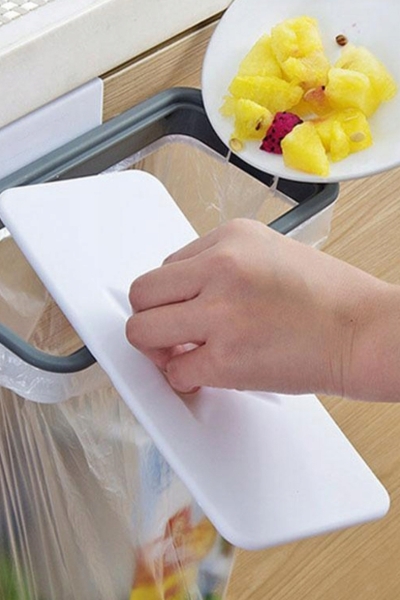 Wyrzucanie resztek jedzenia do worka na uchwycie do worków