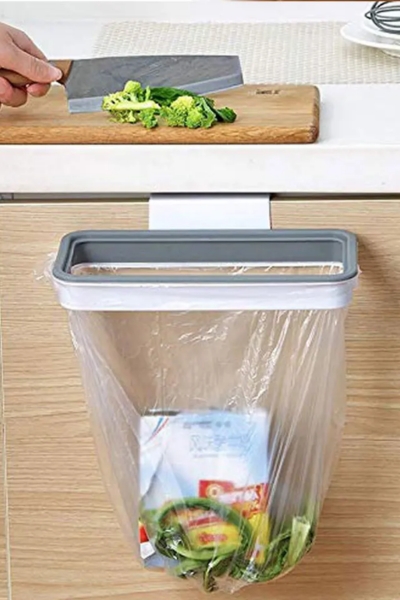 Wyrzucanie resztek jedzenia do worka zamontowanego na uchwycie do worków