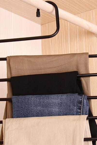 Spodnie zawieszone na wieszaku na spodnie w szafie