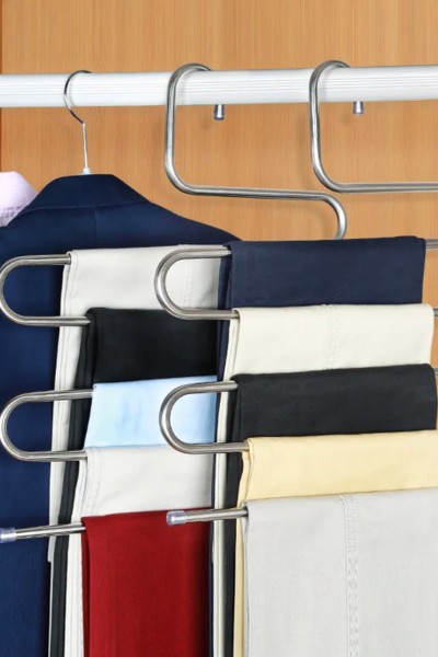 Spodnie zawieszone na wieszaku na spodnie w szafie
