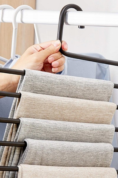 Spodnie zawieszone na wieszaku na spodnie w szafie