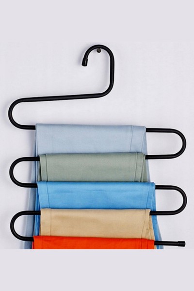 Spodnie zawieszone na wieszaku na spodnie w szafie