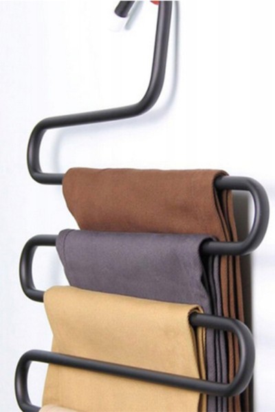 Spodnie zawieszone na wieszaku na spodnie w szafie